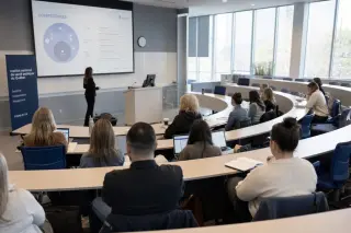 Training amphitheater with adult students attending a morning session, neutral professional decor, modern and calm ambiance.